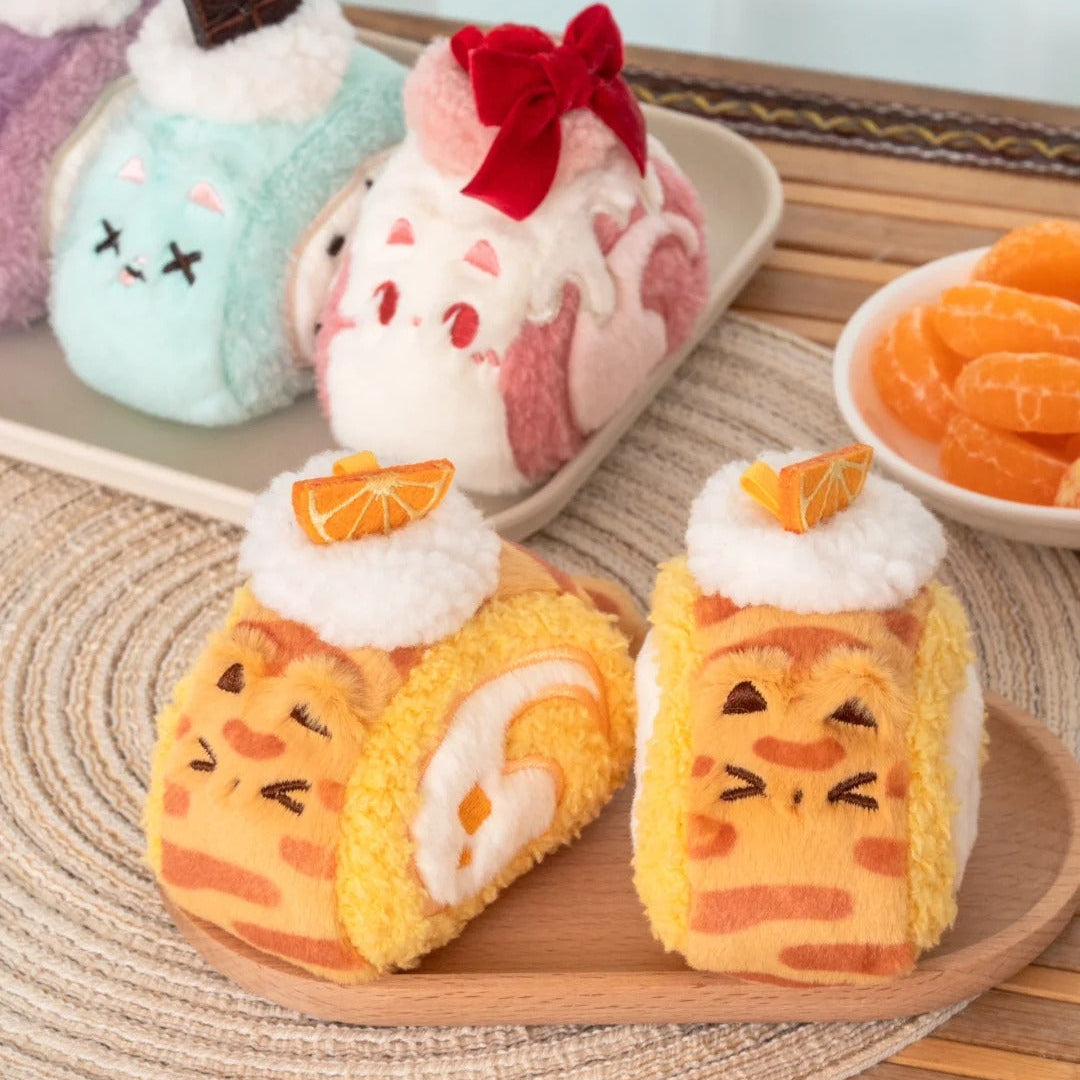 Plush cats shaped like cartoon-style pastries on a wooden surface with a blurred background.