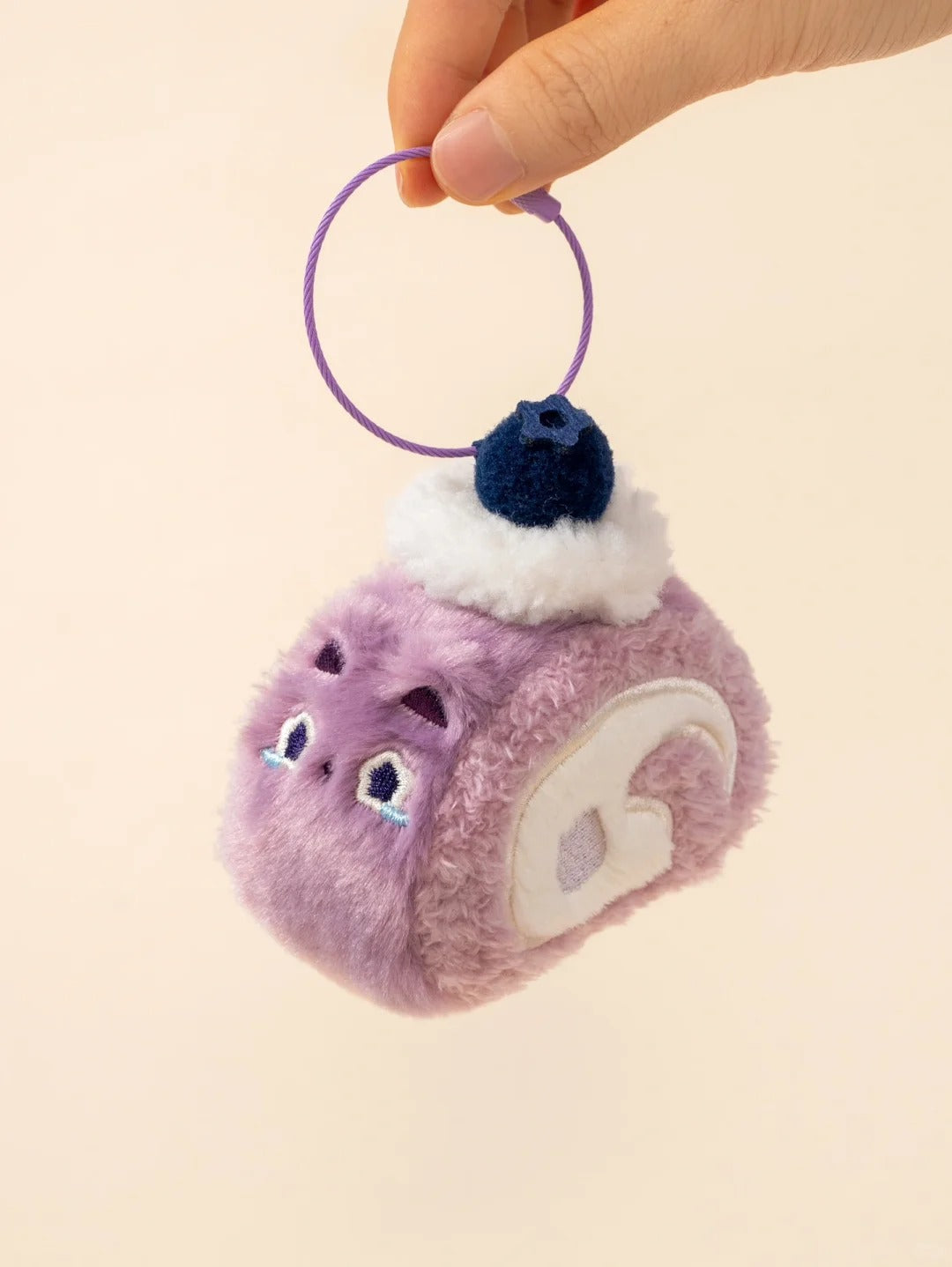 Plush keychain with purple and pink gradient, white accents, and a blueberry on top.