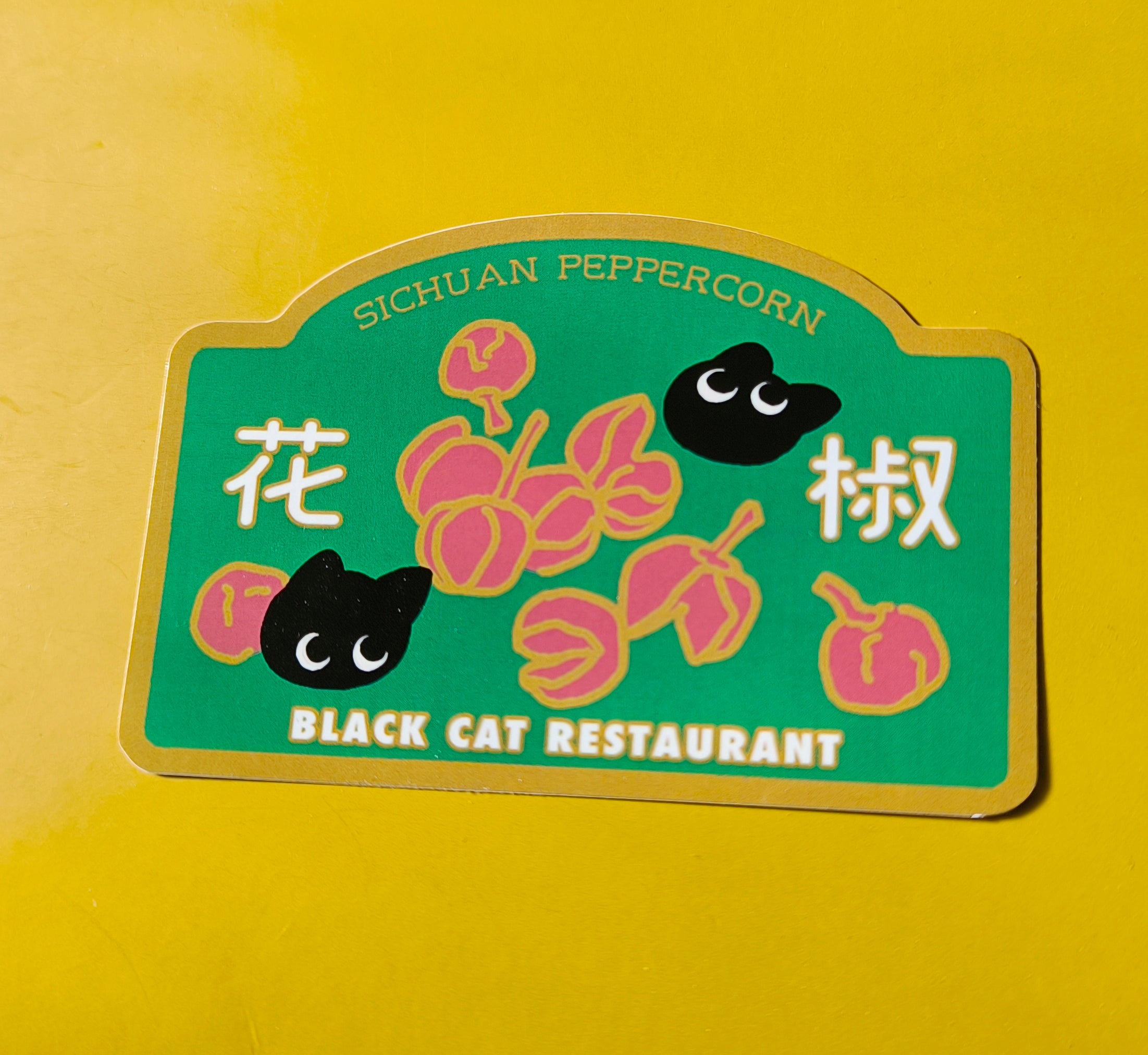 Sticker with black cat design and text on a yellow background