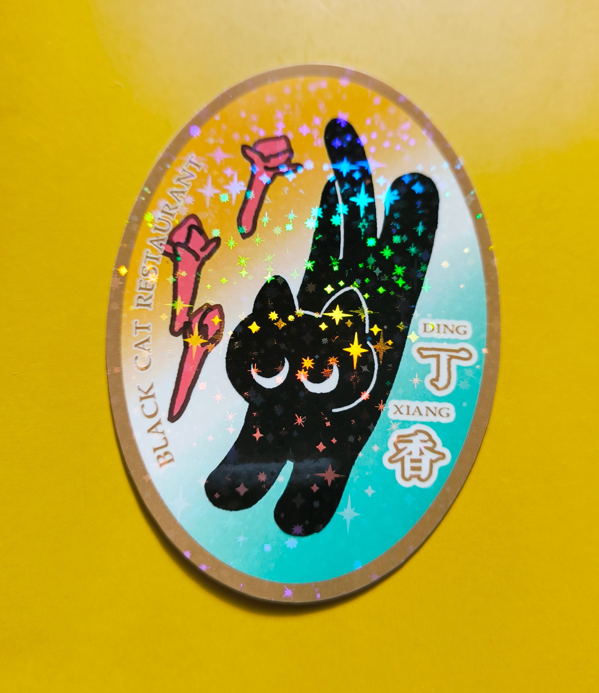 Sticker with black cat design and colorful stars on a yellow background