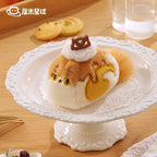 Plush toy resembling a Maine Coon cat on a decorative white stand with cookies in the background.