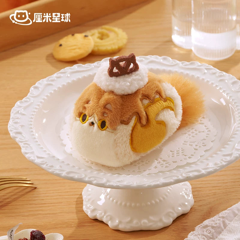 Plush toy resembling a Maine Coon cat on a decorative white stand with cookies in the background.