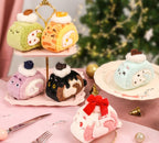 Plush toys shaped like desserts on a pink stand with a blurred Christmas tree in the background.