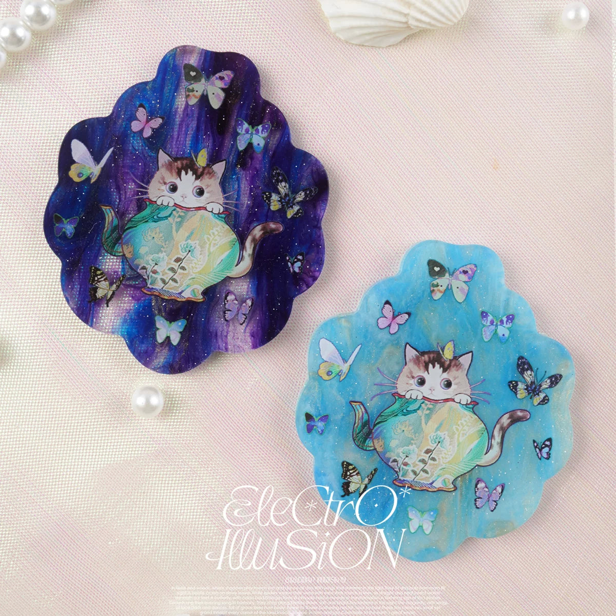 Two decorative magnets with a cat design on a textured surface, featuring the brand 'Electro Illusion'.