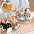 Set of small plush toys resembling cats on a decorative plate.