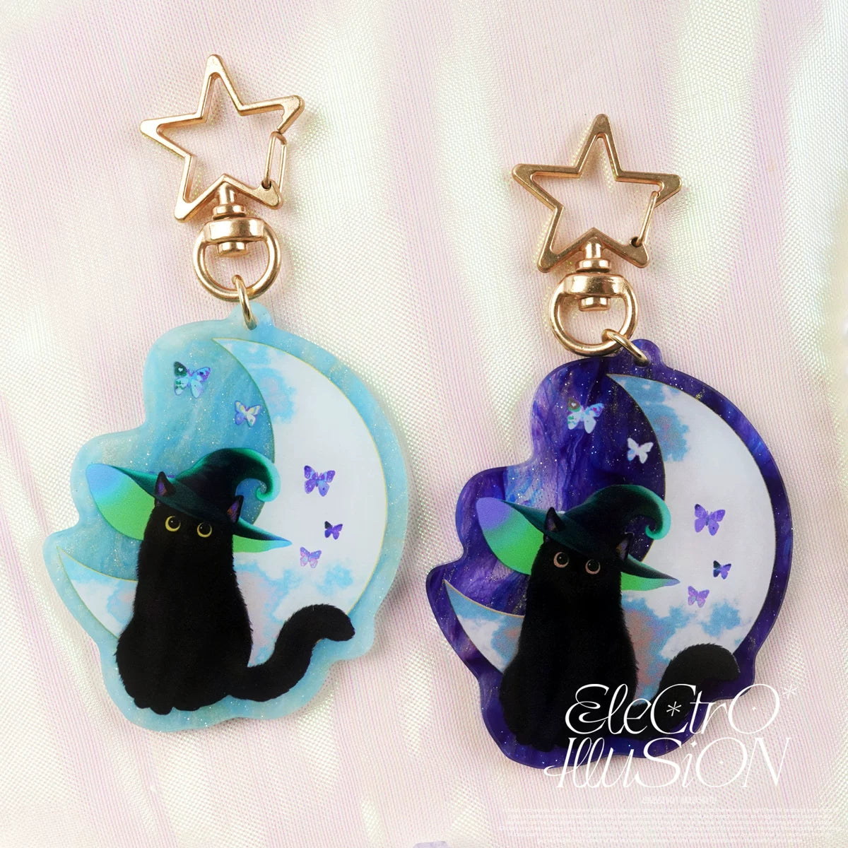 Pair of keychains with black cat design on a light pink background
