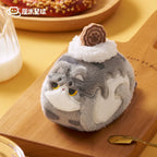 Plush toy resembling a cat with a cookie on a wooden surface