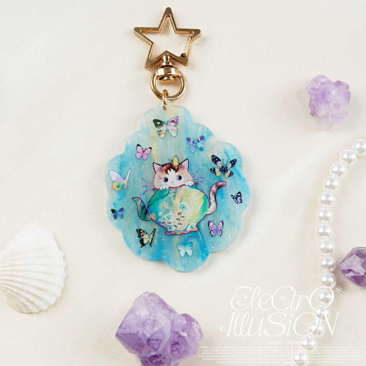 Mermaid cat keychain with star charm on a light background