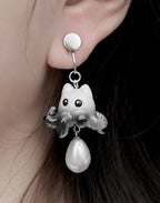 Earring with ghost and pearl design worn by a person