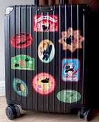 Black suitcase with colorful stickers on a wooden floor