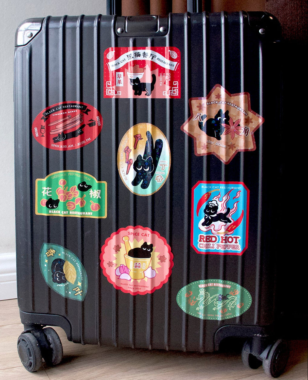 Black suitcase with colorful stickers on a wooden floor