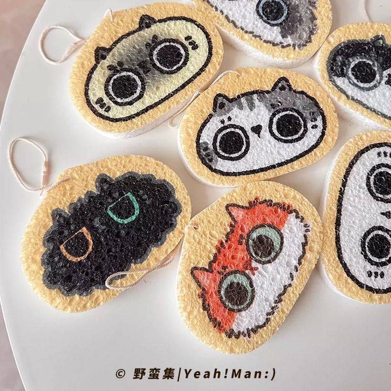 Set of round, colorful cat-themed sponges on a white surface.