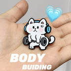 Cartoon cat lifting weights with headphones on, held in a hand with a heart symbol and text 'BODY BUILDING' below.
