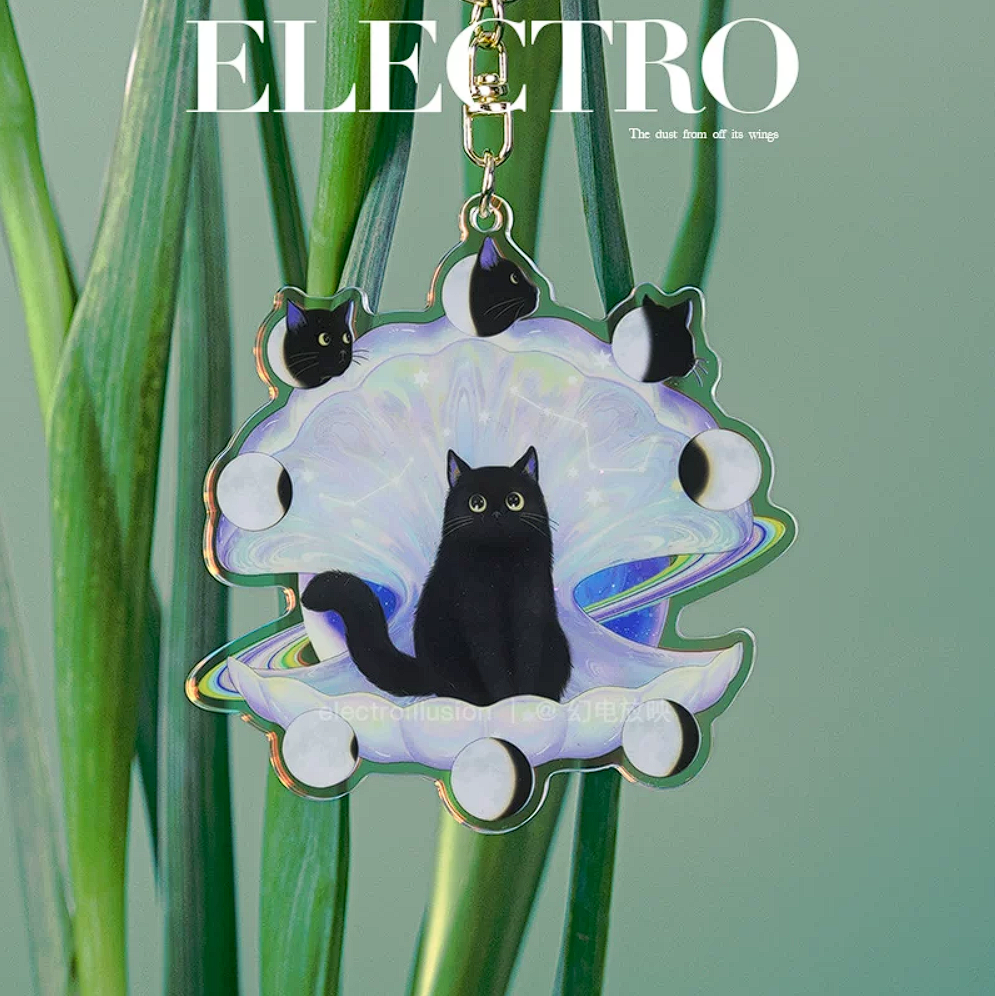 Keychain with black cat design on a green plant background