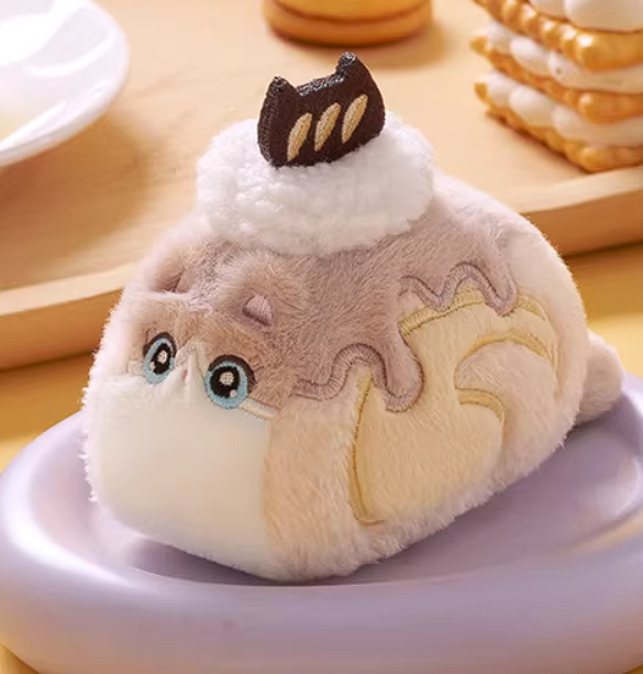 Plush toy resembling a dessert with a cat-like face on a wooden surface