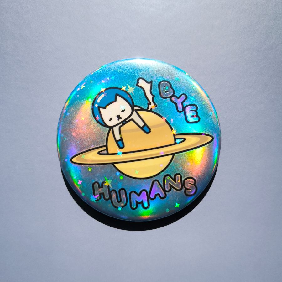 Holographic button with a cat on a planet, saying 'BYE HUMANS' on a gray background