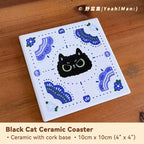 Black cat ceramic coaster with blue patterns on a wooden surface