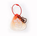 Clear plastic keychain with guitar design on a white background