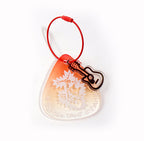 Clear plastic keychain with guitar design on a white background