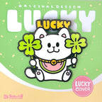 Enamel pin pf a cartoon cat with four-leaf clover on a green background with 'LUCKY' text