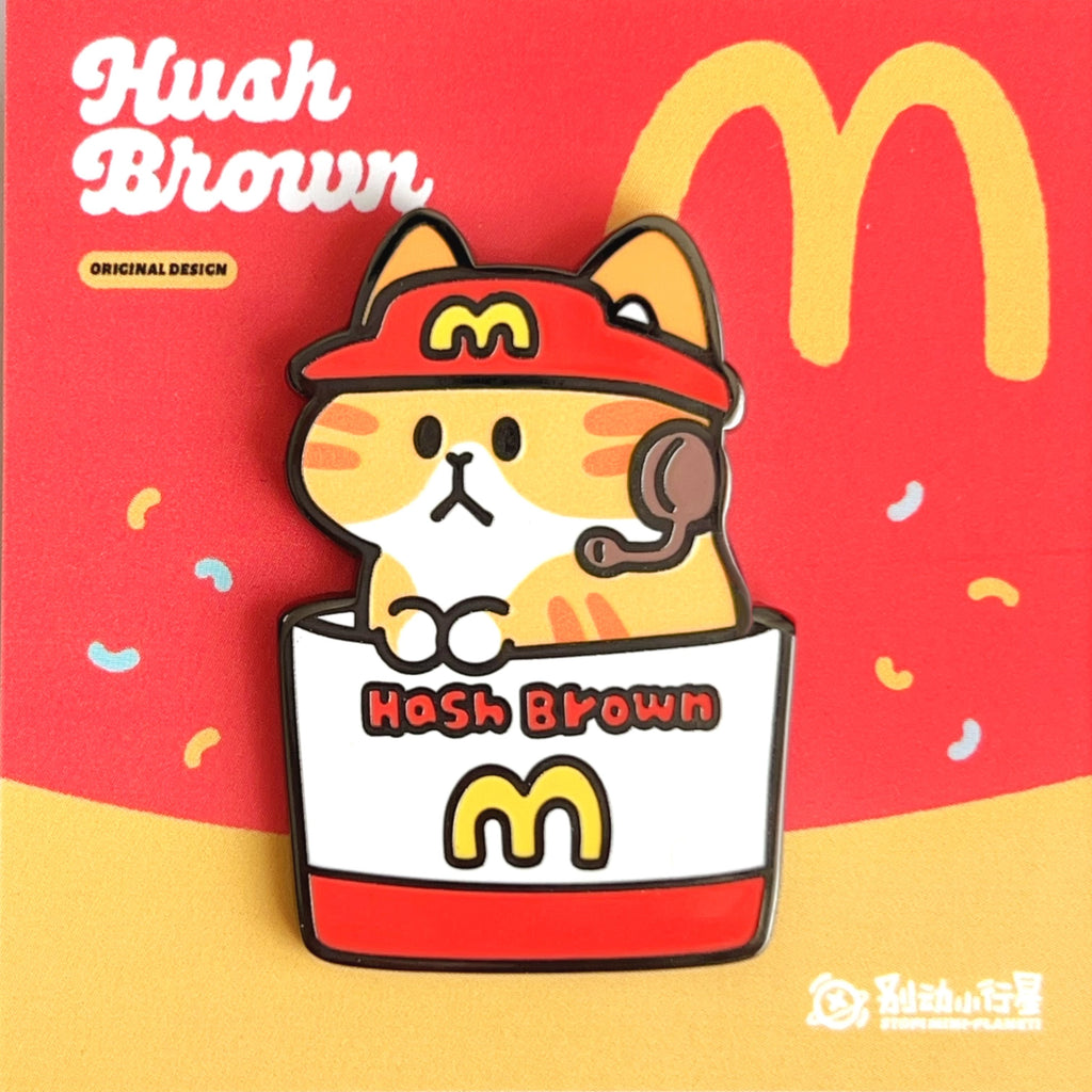 Enamel pin of Hash Brown themed pin with a cartoon cat on a red and yellow background