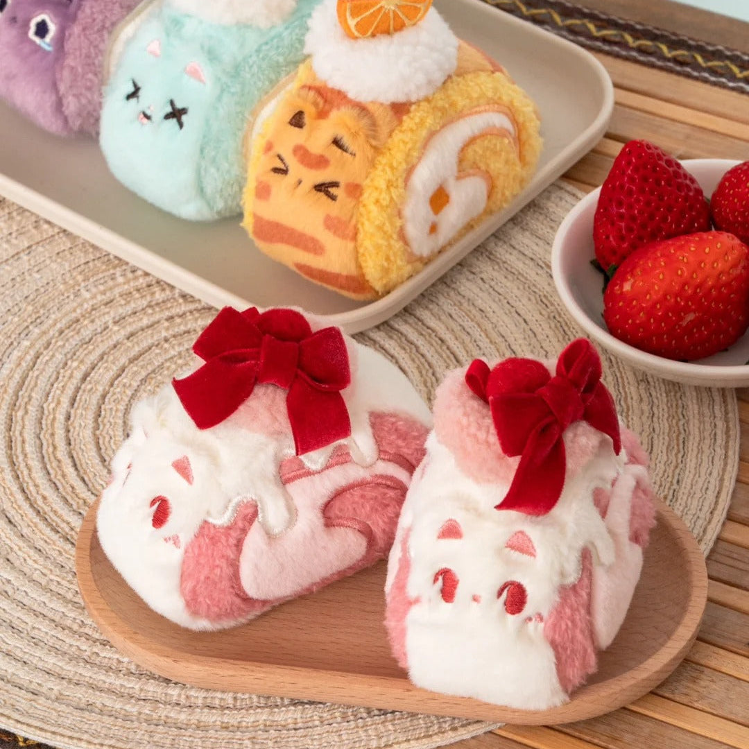 Plush toys resembling dessert rolls with faces on a wooden tray.