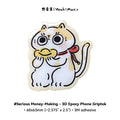 3D epoxy phone grip with cartoon cat design on a white background