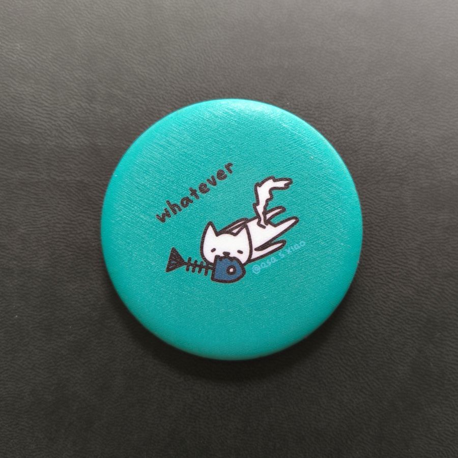 Teal button with a cartoon cat and text 'whatever' on a black background